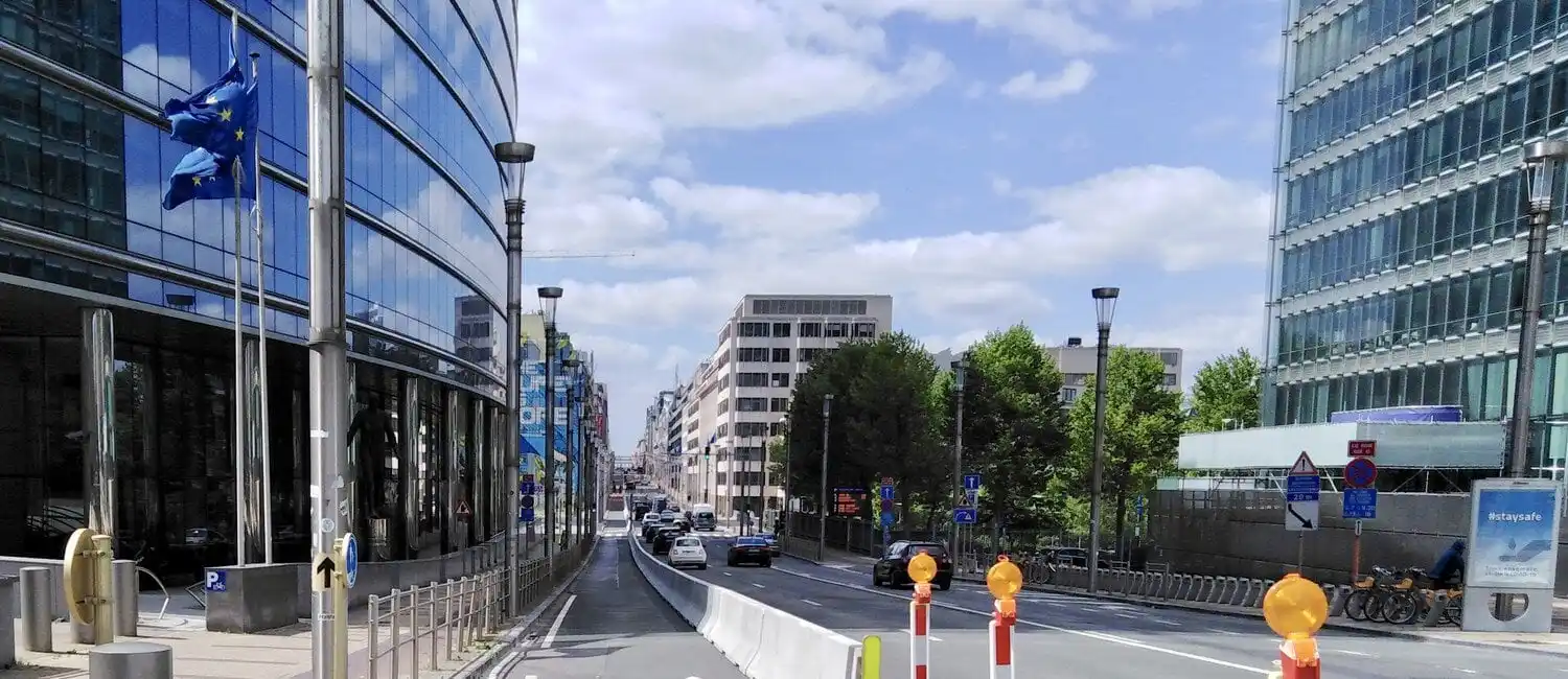 Rue urbaine avec un trottoir à gauche et une piste cyclable séparée de la chaussée par des barrières en béton.