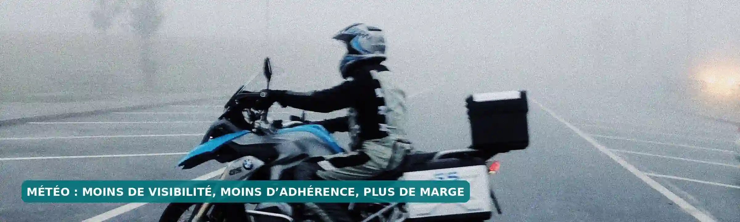 Motard dans un brouillard dense, avec une visibilité réduite sur les alentours.
