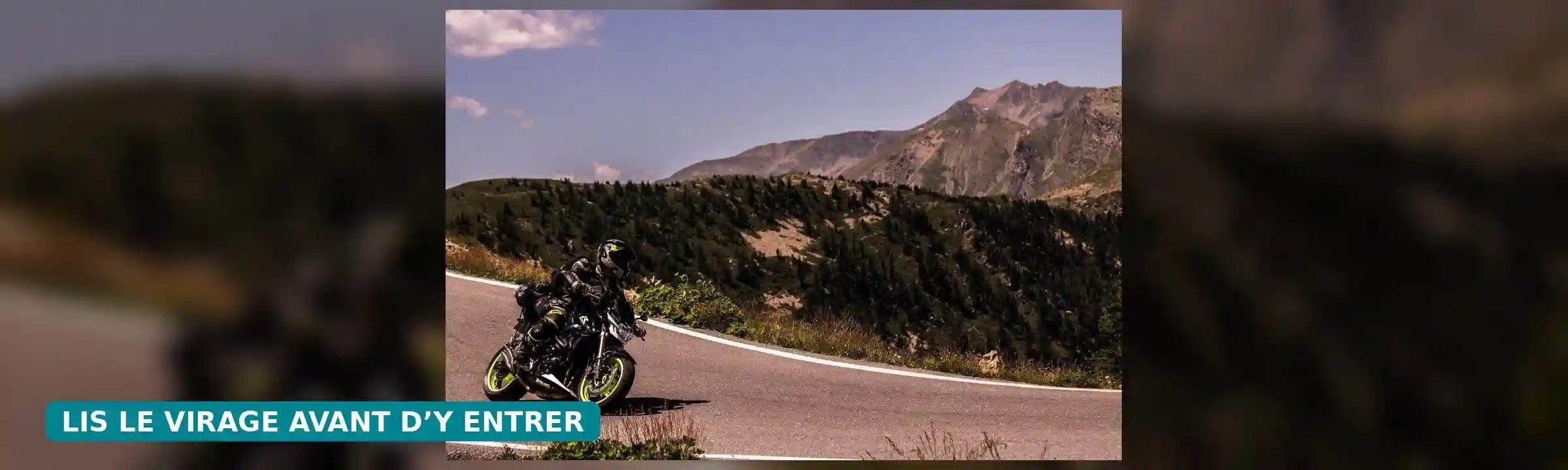 Motard incliné dans un virage sur une route de montagne, avec le conseil « Lis le virage avant d’y entrer ».