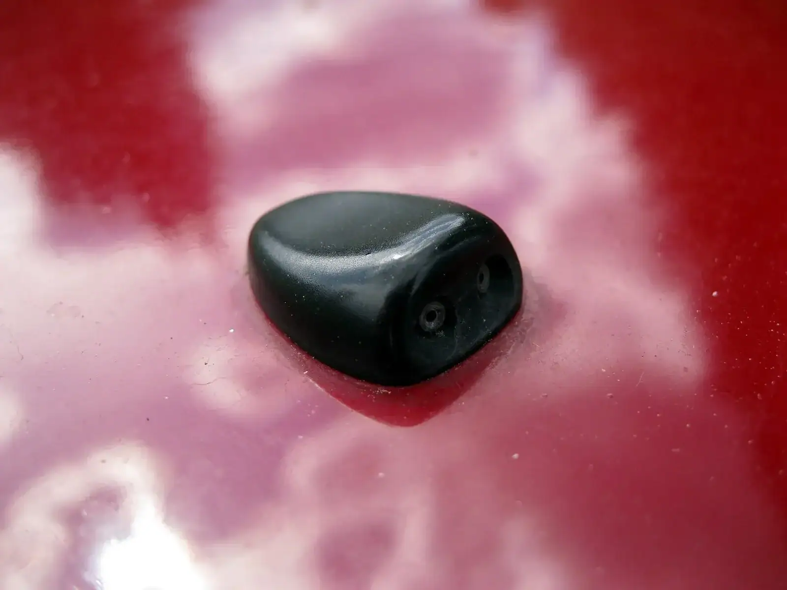 Buse de lave-glace à deux orifices sur le capot d’une voiture.