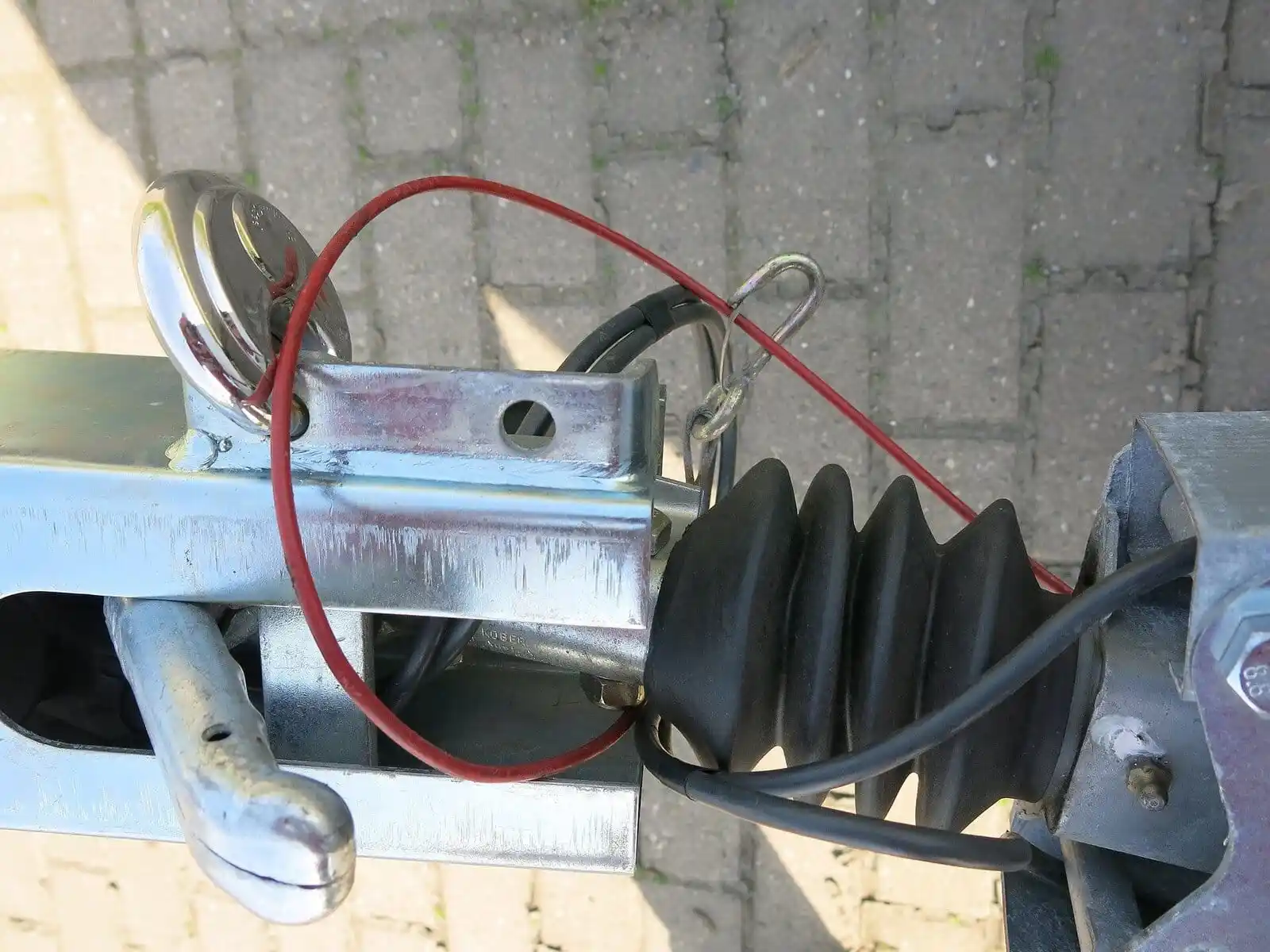 Câble de rupture rouge formant une boucle au-dessus du dispositif d’attelage d’une remorque.