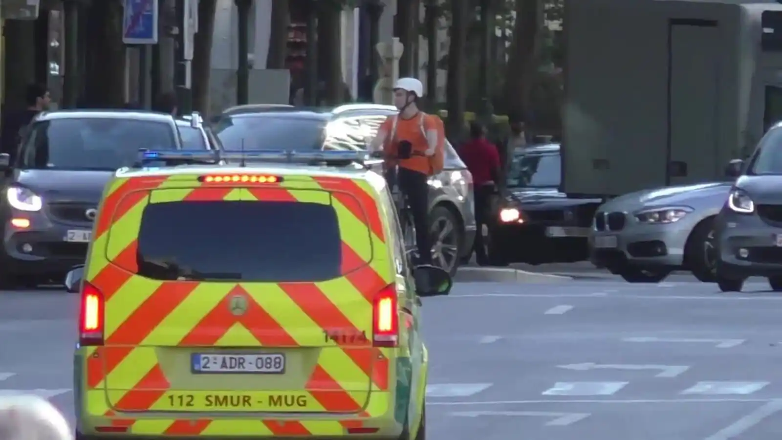 Véhicule de secours vu de l’arrière, avec une lumière bleue allumée sur le toit ; des voitures et un camion occupent la chaussée plus loin.