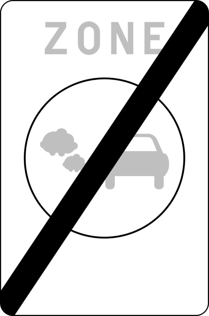 Panneau de fin de zone de basses émissions, avec une voiture et des gaz d’échappement grisés, barré d’une diagonale noire.
