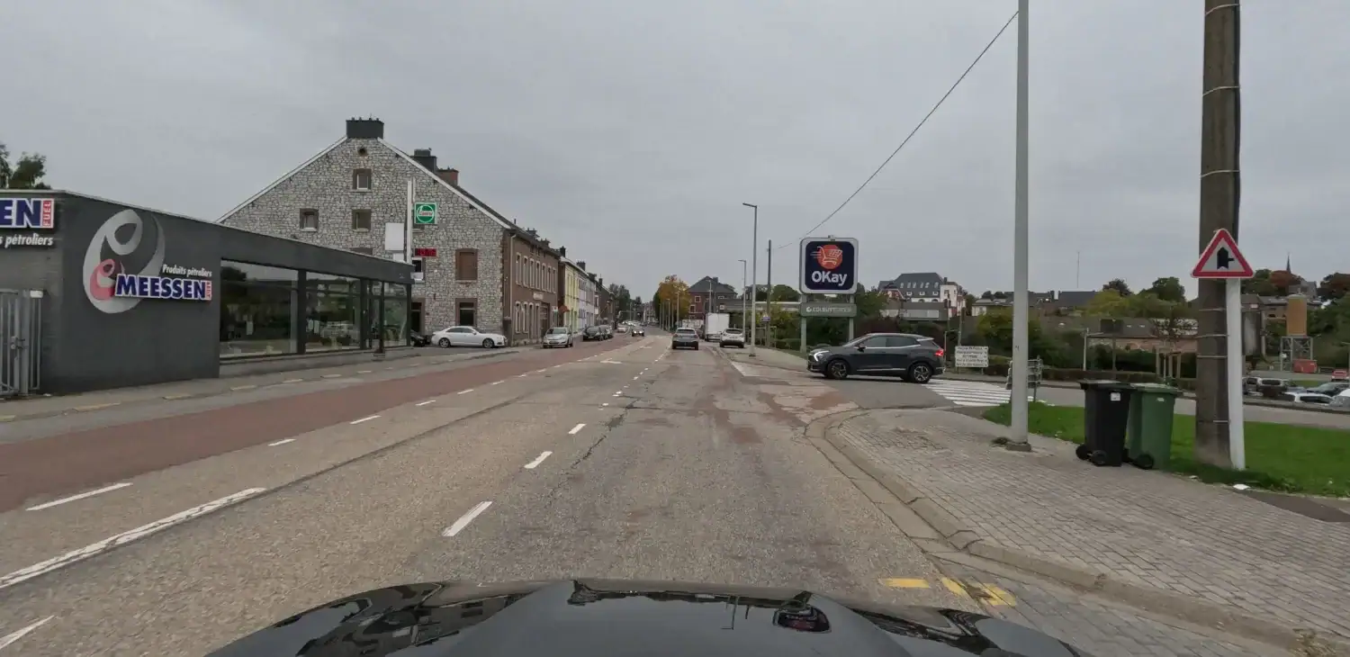 Carrefour avec une voie débouchant à droite et une voiture près du passage pour piétons de cette voie.