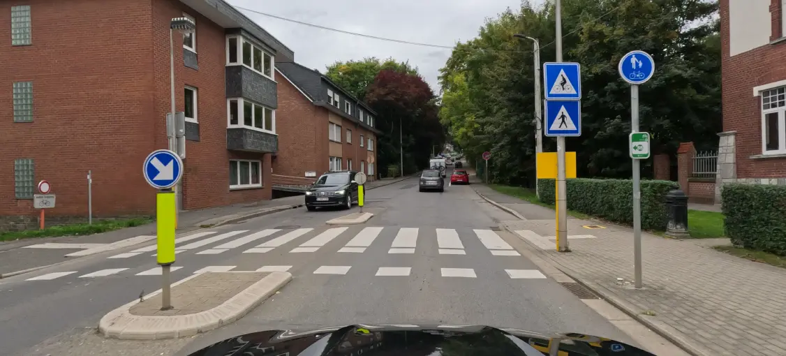 Passage piéton à bandes blanches, accompagné d’une traversée cyclable délimitée par des marques blanches carrées. Aucun usager n’est engagé sur les traversées.