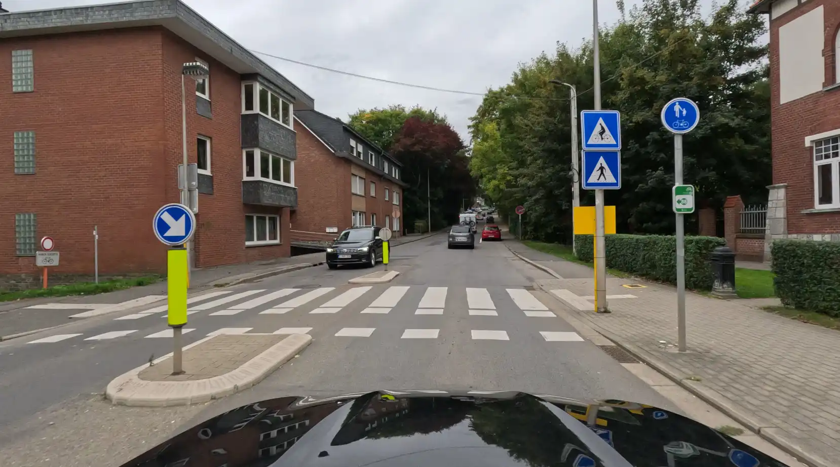 Passages pour piétons et pour cyclistes côte à côte, avec des îlots centraux et une flèche indiquant de passer à droite.