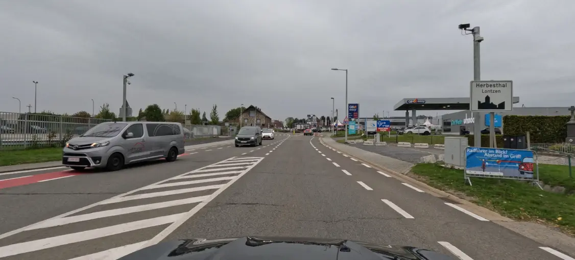 Zone de hachures blanches obliques au premier plan, à gauche de la bande de circulation suivie.