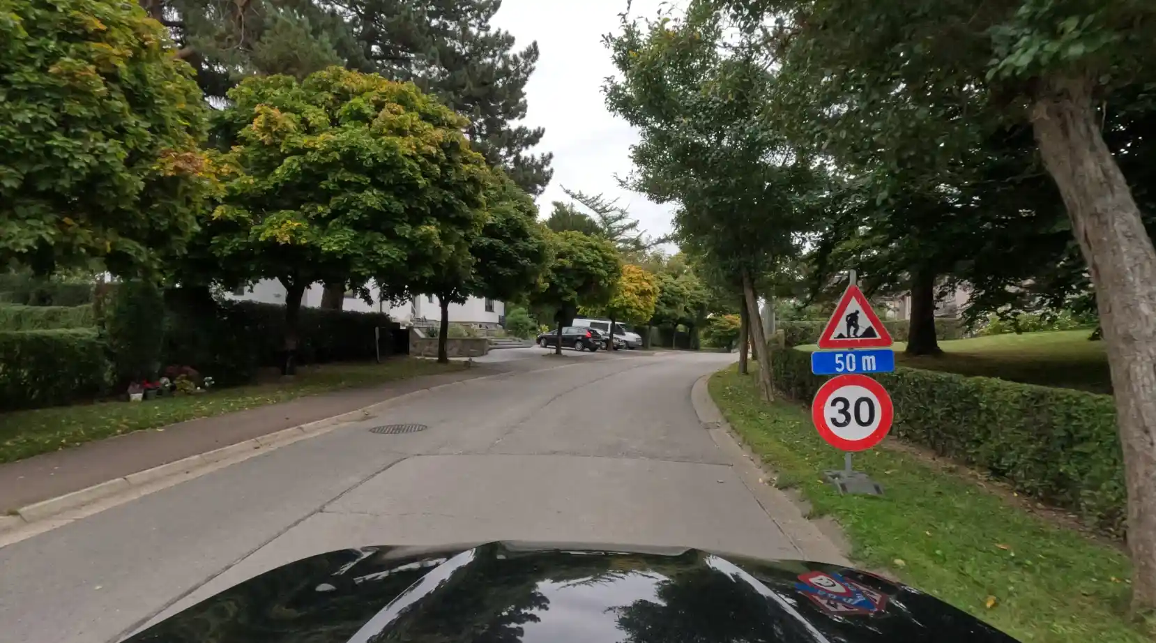 À droite, signal de travaux avec un panonceau « 50 m », au-dessus d’un signal de limitation à 30 km/h.