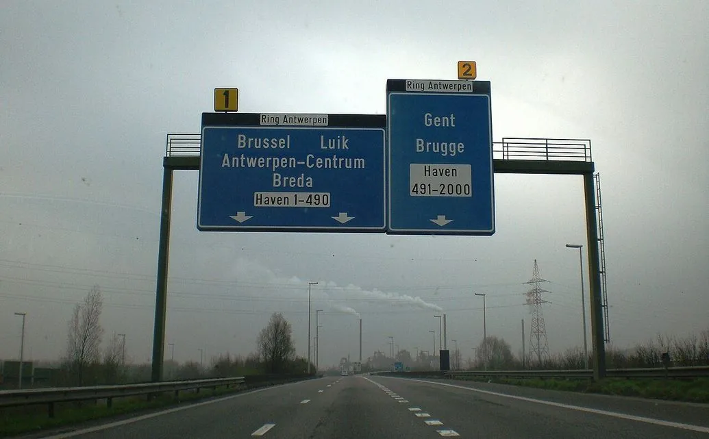Autoroute A12 : panneaux au-dessus des bandes indiquant notamment Brussel et Luik à gauche, Gent et Brugge à droite.